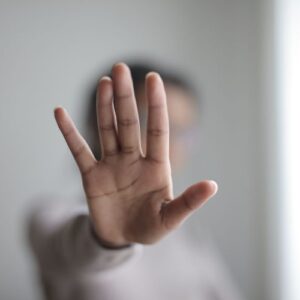 Eine Hand, die mit der mit der Handfläche nach außen zeigt: das heißt "Nein", oder "Stopp"