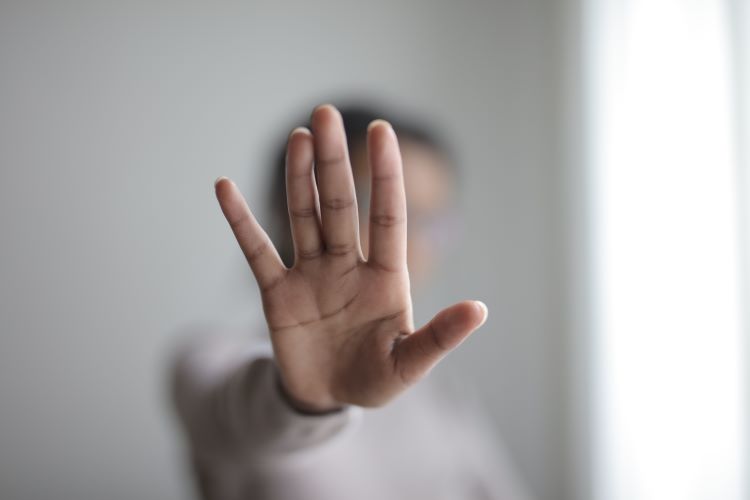 Eine Hand, die mit der mit der Handfläche nach außen zeigt: das heißt "Nein", oder "Stopp"